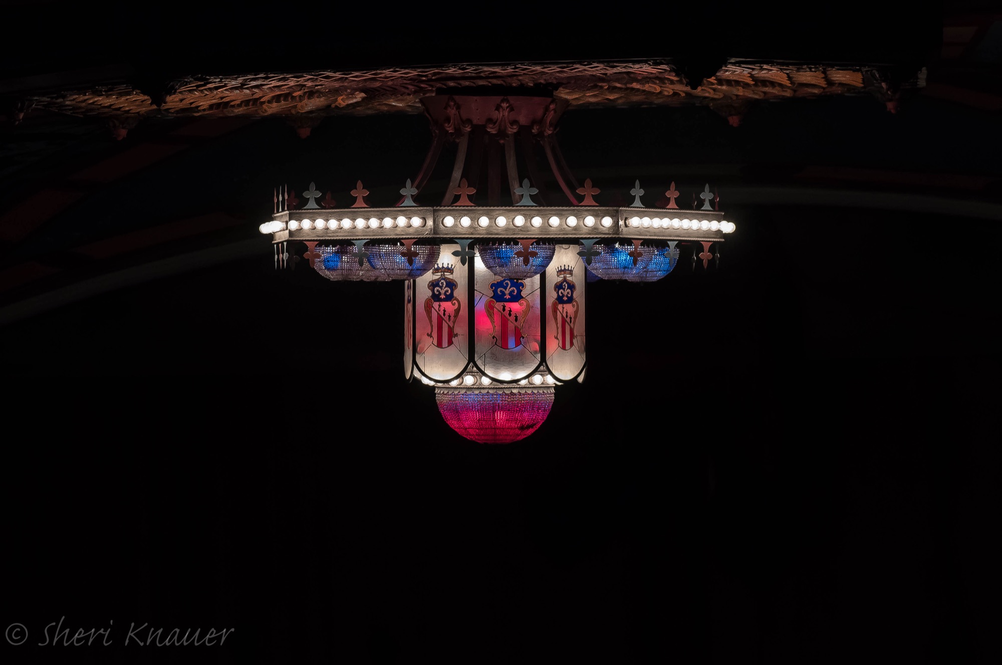 The chandelier glowing alone in the darkened auditorium. Photo by Sheri Knauer