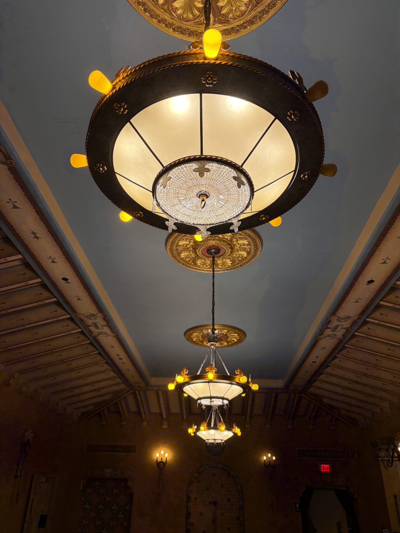 Restored pendant lights running the length of a theater corridor